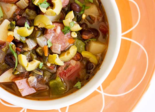 Soup with andouille, black beans, chile, tomatoes, pototes and olives