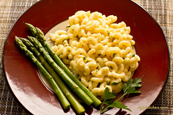 A plate with tarragon scented stovetop macaroni and cheese and a side of asparagus