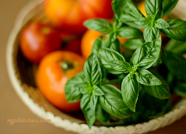 Image of A basket of fresh tomatoes and basil