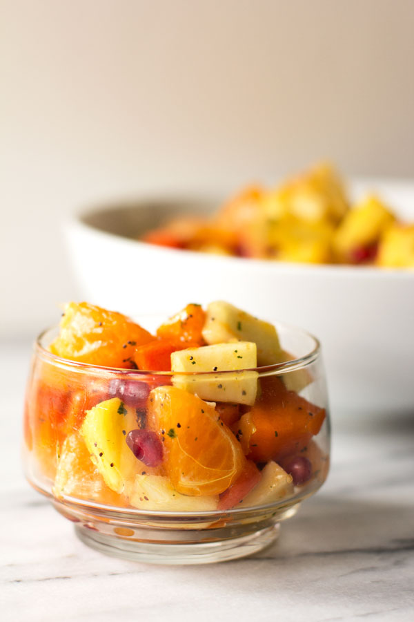 A winter fruit salad made with pineapple, persimmon, citrus and pomegranate) topped with a honey ginger dressing #fruit #salad #persimmon @mjskitchen