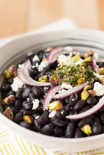 A mouthwatering bowl of black beans, chimichurri, and pickled onion with cotija cheese and pistachios. #blackbeans #chimichurri @mjskitchen